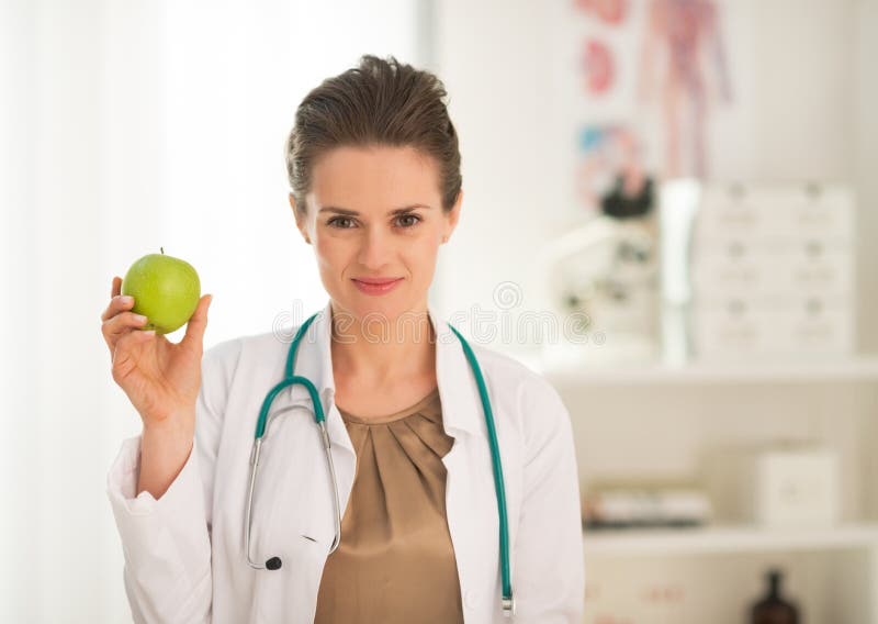 För kvinnavisning för medicinsk doktor äpple arkivfoto För kvinnavisning för medicinsk doktor äpple arkivfoto