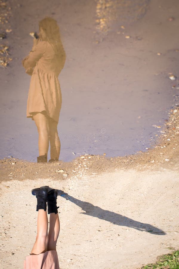För reflexionspöl för ung kvinna som modell poserar inverterat uppochnervänt arkivfoto För reflexionspöl för ung kvinna som modell poserar inverterat uppochnervänt arkivfoto