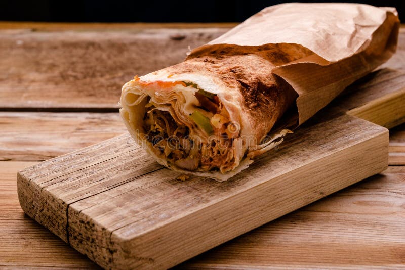 För Shawarma för Doner kebabgyroskop rulle nötkött i smörgås för pittabrödsjal på träbakgrund kopiera avstånd royaltyfria foton För Shawarma för Doner kebabgyroskop rulle nötkött i smörgås för pittabrödsjal på träbakgrund kopiera avstånd royaltyfria foton