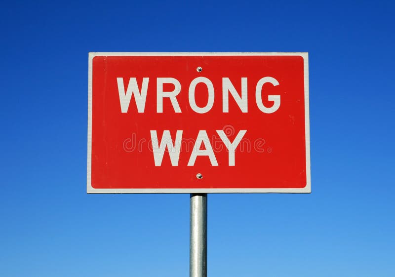 Wrong way road sign on a blue sky background. Wrong way road sign on a blue sky background