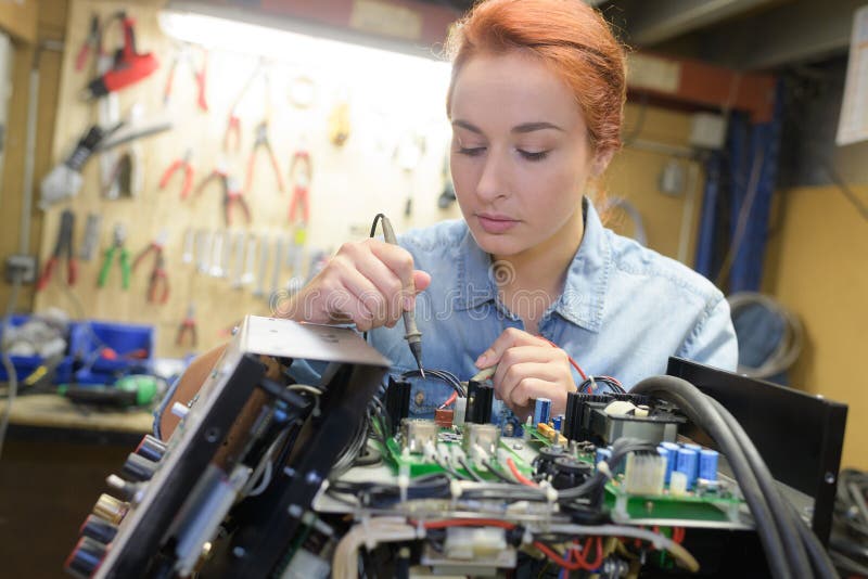 För teknikerreparationen för den unga kvinnan apparaten för elektronik tonade bild royaltyfri bild