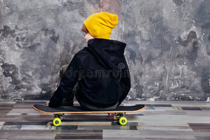 För ungdomtrender för ung pojke tonårig stående för studio med skateboarden arkivfoton För ungdomtrender för ung pojke tonårig stående för studio med skateboarden arkivfoton