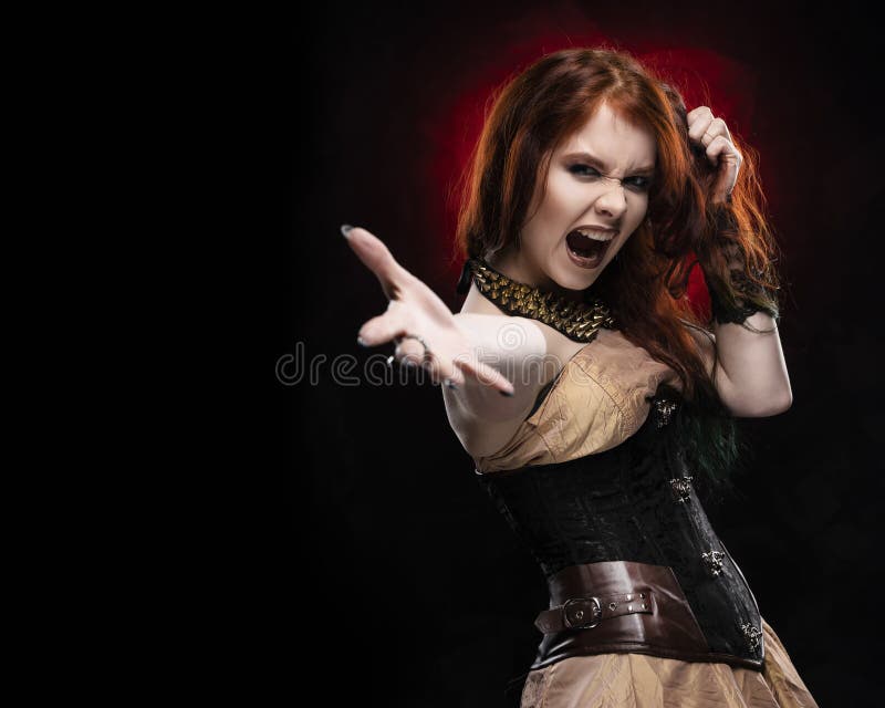För Viktoriansk-stil för härlig rödhårig mancosplayerflicka bärande skrin för klänning steampunk, shooks hennes hår med hennes ha arkivfoton För Viktoriansk-stil för härlig rödhårig mancosplayerflicka bärande skrin för klänning steampunk, shooks hennes hår med hennes ha arkivfoton