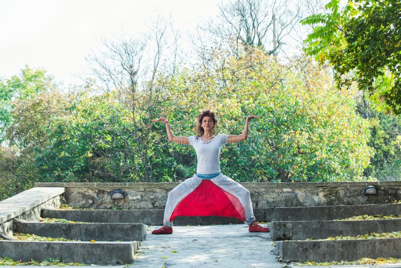 För övningsyoga för den unga kvinnan gudinnan för dagen för hösten poserar den utomhus- royaltyfri foto För övningsyoga för den unga kvinnan gudinnan för dagen för hösten poserar den utomhus- royaltyfri foto