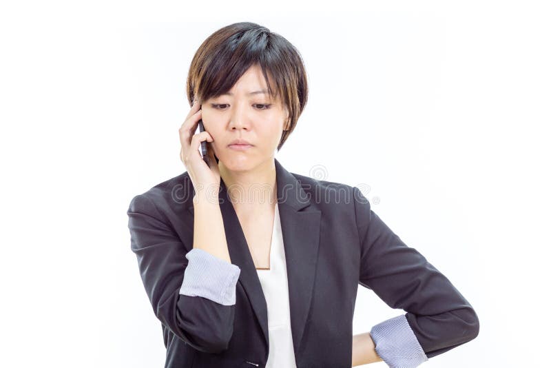 Förargad asiatisk affärskvinna på mobiltelefonen arkivfoto