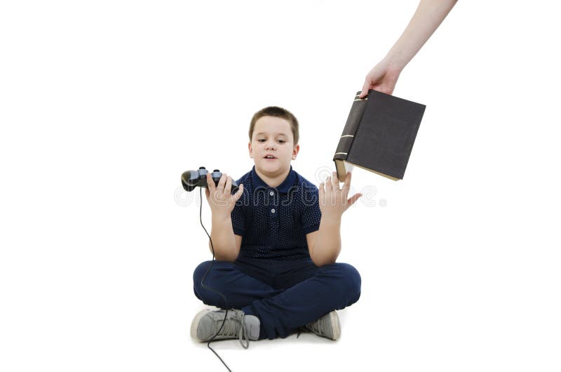 Förargad pojke Handen för ` s för modern för pyslekvideospel sätter honom en bok för att lära arkivfoton Förargad pojke Handen för ` s för modern för pyslekvideospel sätter honom en bok för att lära arkivfoton
