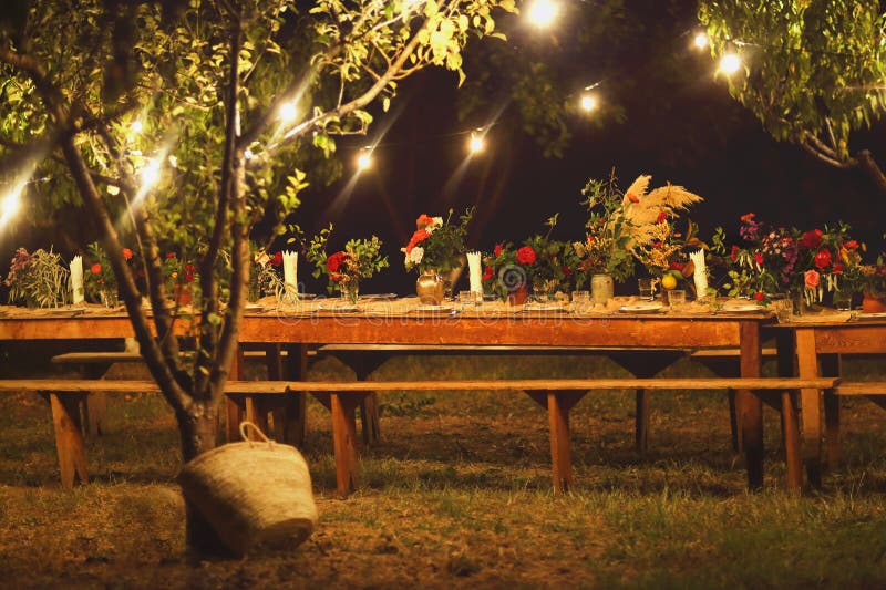 Förberedd tabell för en lantlig utomhus- matställe på natten med winegla arkivfoto Förberedd tabell för en lantlig utomhus- matställe på natten med winegla arkivfoto