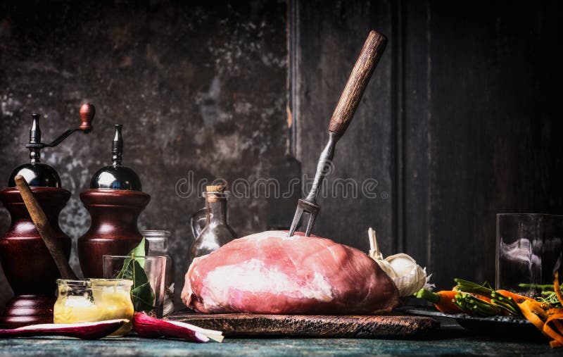 Förberedelse av rått grisköttskinkakött på det lantliga köksbordet på mörk träbakgrund arkivfoto Förberedelse av rått grisköttskinkakött på det lantliga köksbordet på mörk träbakgrund arkivfoto