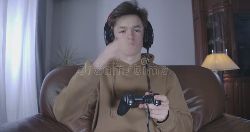Förbrukad blek tonåring som somnar vid uppspelning av videospel. En bild av brunette caucasian-pojken som tillbringar dag och natt lager videofilmer