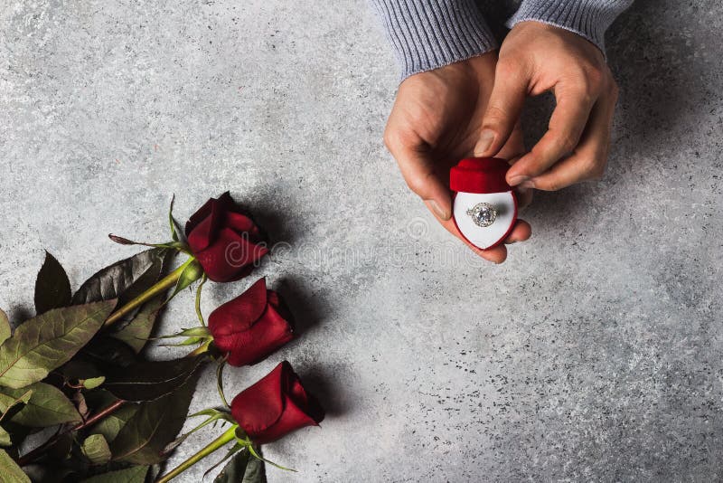 Förlovningsringen för den romantiska handen för mannen för valentindagen att gifta sig den hållande i ask mig bröllop royaltyfri bild Förlovningsringen för den romantiska handen för mannen för valentindagen att gifta sig den hållande i ask mig bröllop royaltyfri bild