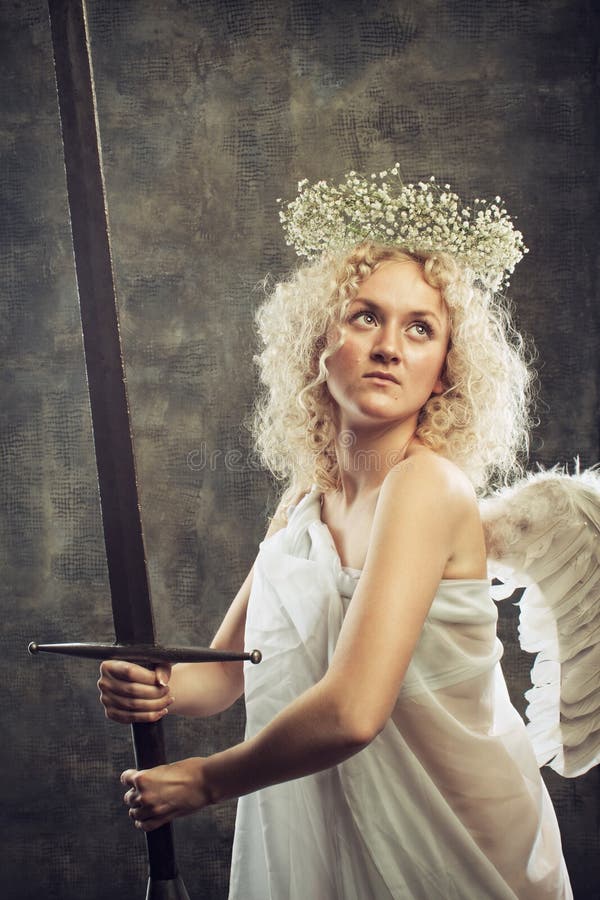 Little angel with large sword over grange background. Little angel with large sword over grange background