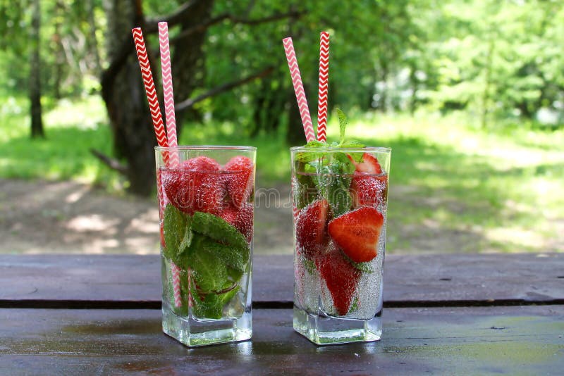 Förnyande sommarförkylning dricker jordgubben med citronen, limefrukt, gurkan, mintkaramellen, ingefäran i exponeringsglas och ti royaltyfria foton Förnyande sommarförkylning dricker jordgubben med citronen, limefrukt, gurkan, mintkaramellen, ingefäran i exponeringsglas och ti royaltyfria foton