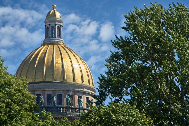 Magnificent gilded dome of a huge Orthodox cathedral in the city center, decorated along the perimeter with numerous statues, architecture in classical European style, city landmark, green trees, sky and clouds, history and culture, religion, summer. Magnificent gilded dome of a huge Orthodox cathedral in the city center, decorated along the perimeter with numerous statues, architecture in classical European style, city landmark, green trees, sky and clouds, history and culture, religion, summer.