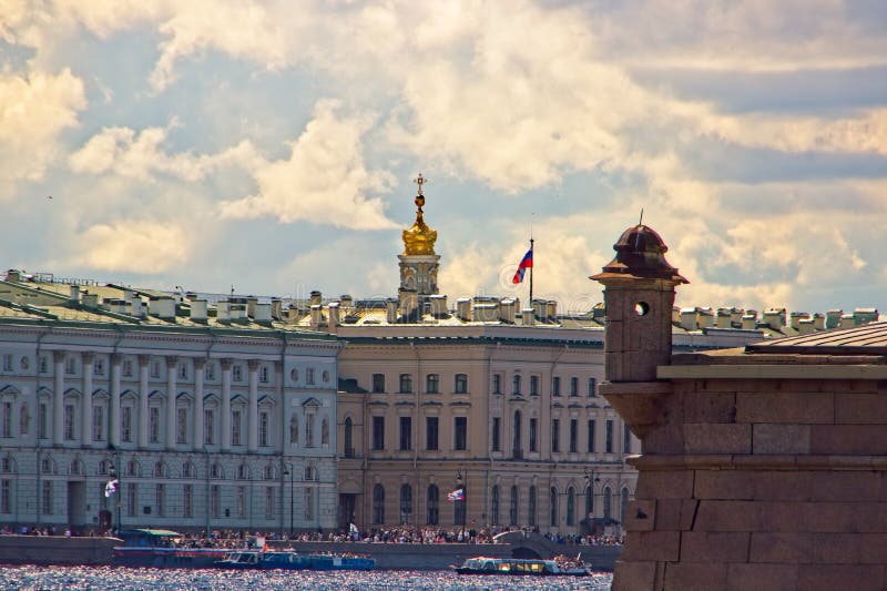 View of the embankment in the city center with ancient buildings of classical architecture along the river, holiday flags, roofs and dome of the cathedral, a fragment of the fortress wall with a tower, people on the embankment, holiday, cityscape, summer. View of the embankment in the city center with ancient buildings of classical architecture along the river, holiday flags, roofs and dome of the cathedral, a fragment of the fortress wall with a tower, people on the embankment, holiday, cityscape, summer.