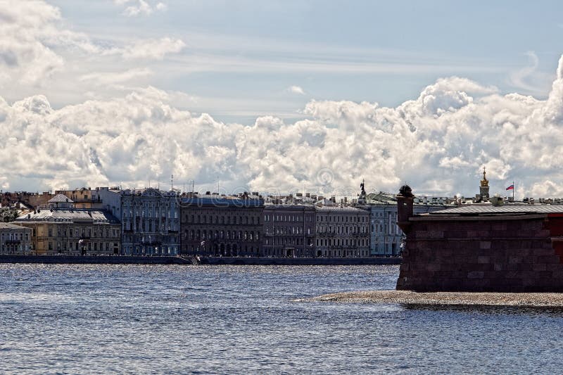 View of the embankment in the city center with ancient buildings of classical architecture along the river, holiday flags, roofs and dome of the cathedral, a fragment of the fortress wall with a tower, people on the embankment, holiday, cityscape, summer. View of the embankment in the city center with ancient buildings of classical architecture along the river, holiday flags, roofs and dome of the cathedral, a fragment of the fortress wall with a tower, people on the embankment, holiday, cityscape, summer.