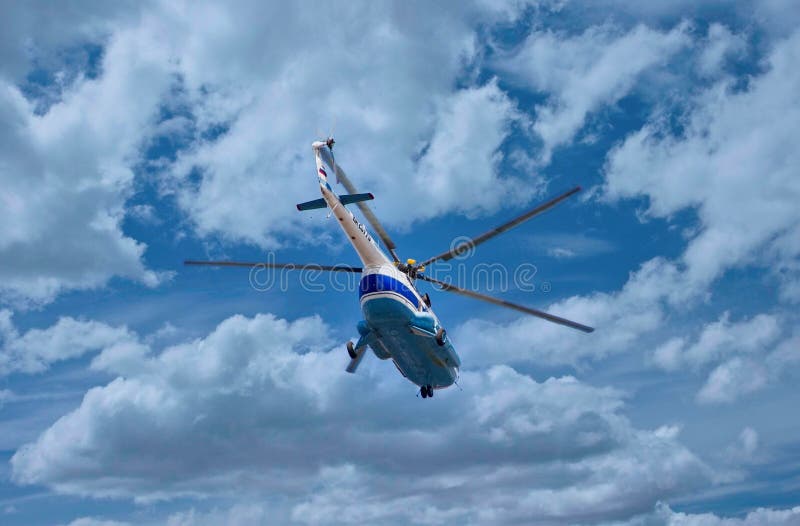 Beautiful view of a vintage helicopter flying in the sky against the background of clouds and blue sky, vehicle with horizontal propellers, aircraft, beauty and technology, sunlight, stock photo, summer. Beautiful view of a vintage helicopter flying in the sky against the background of clouds and blue sky, vehicle with horizontal propellers, aircraft, beauty and technology, sunlight, stock photo, summer.