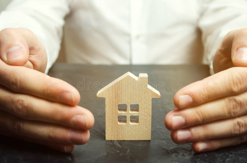 Försäkringmedlet skyddar huset med en gest av skydd Begreppet av skydd och hus för egenskapsförsäkring arkivbilder Försäkringmedlet skyddar huset med en gest av skydd Begreppet av skydd och hus för egenskapsförsäkring arkivbilder