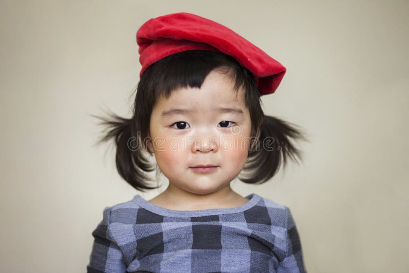 Förtjusande asiatiskt barn som innocently ser kameran royaltyfria foton Förtjusande asiatiskt barn som innocently ser kameran royaltyfria foton