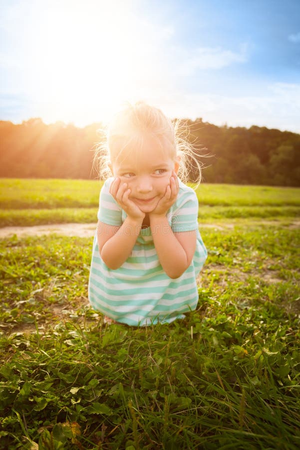 Förtjusande blond liten flicka med uppnosigt leende royaltyfri bild Förtjusande blond liten flicka med uppnosigt leende royaltyfri bild