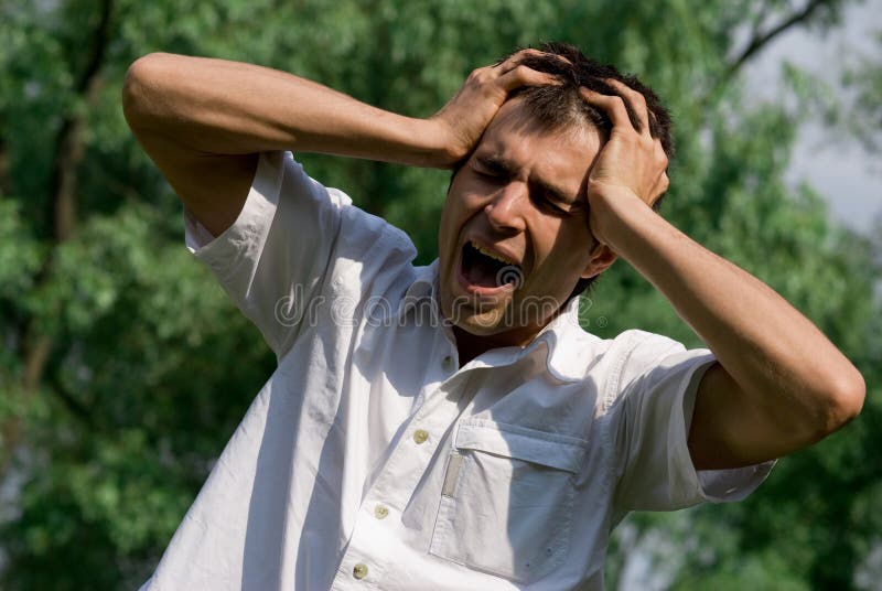 Young man in absolute despair and stress outdoor. Young man in absolute despair and stress outdoor