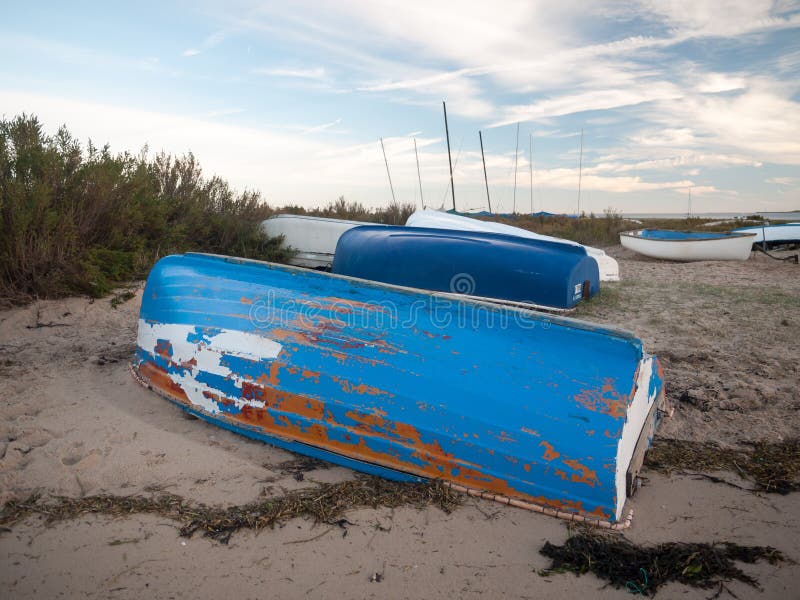 Förtöjde det uppochnervända blått gå i flisor målade privata fartyget på stranden royaltyfri bild Förtöjde det uppochnervända blått gå i flisor målade privata fartyget på stranden royaltyfri bild