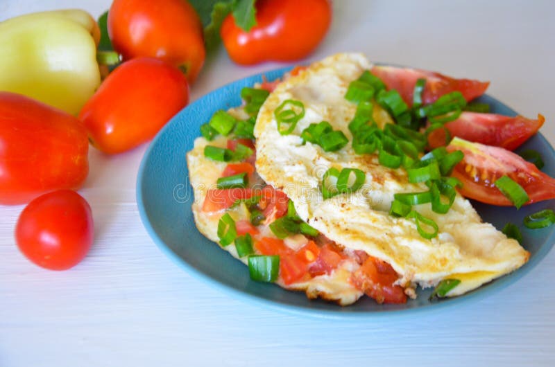 Förvanskade ägg med tomater och salladslökar fotografering för bildbyråer Förvanskade ägg med tomater och salladslökar fotografering för bildbyråer