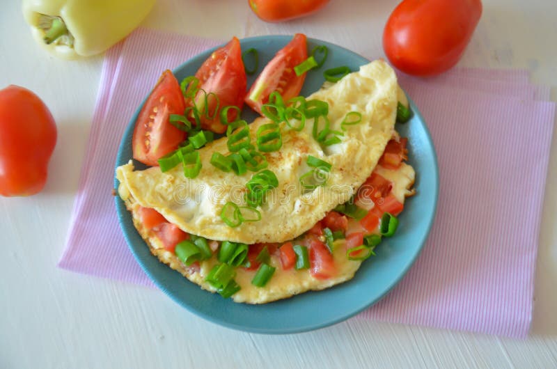Förvanskade ägg med tomater och salladslökar royaltyfri fotografi Förvanskade ägg med tomater och salladslökar royaltyfri fotografi