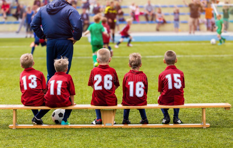 Fútbol Team Sitting de los muchachos en banco de la substitución Partido del torneo del fútbol de la escuela de los niños