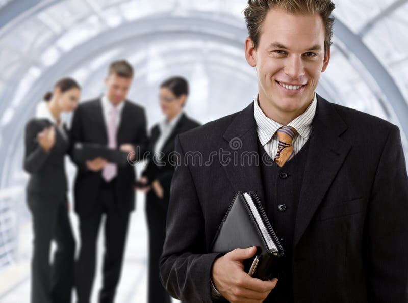 Businessman leading team of business people working in background. Businessman leading team of business people working in background.