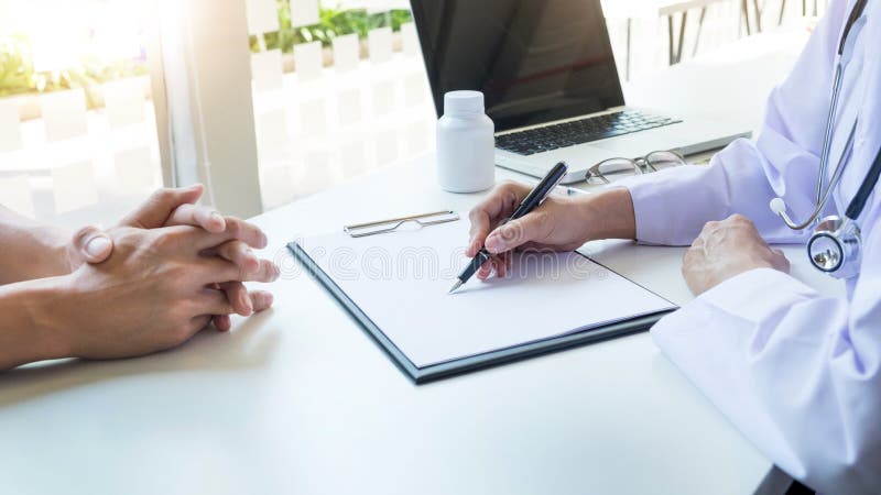 Füllende Patientenanamneseliste des Ärztinhandgriffsilberstiftes stockbild Füllende Patientenanamneseliste des Ärztinhandgriffsilberstiftes stockbild