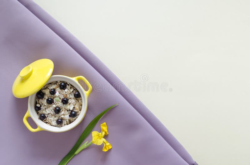 Gachas de avena amarillas del desayuno sano de la visión superior, muesli con los arándanos frescos y pasas imagen de archivo libre de regalías Gachas de avena amarillas del desayuno sano de la visión superior, muesli con los arándanos frescos y pasas imagen de archivo libre de regalías