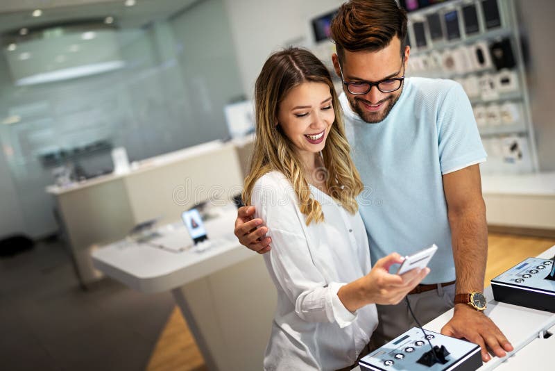 Gadgetkoncept för teknisk shoppingenhet. Ungdomar som vill köpa en ny smarttelefon i mobilbutiken. arkivbild