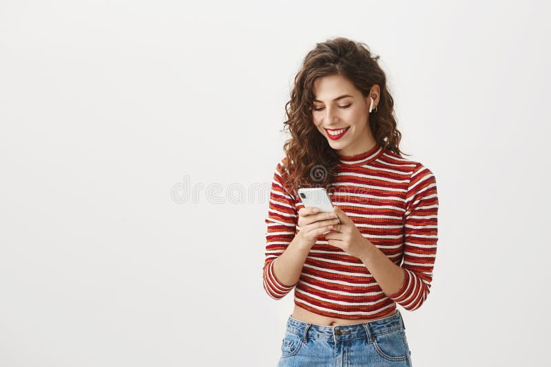 Gadgets are future. Portrait of excited happy european woman with curly hairstyle and red lipstick wearing trendy