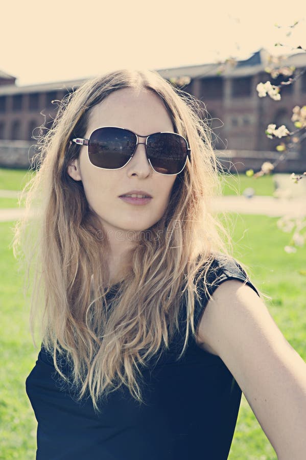 Gafas de sol que desgastan de la mujer joven fotografía de archivo