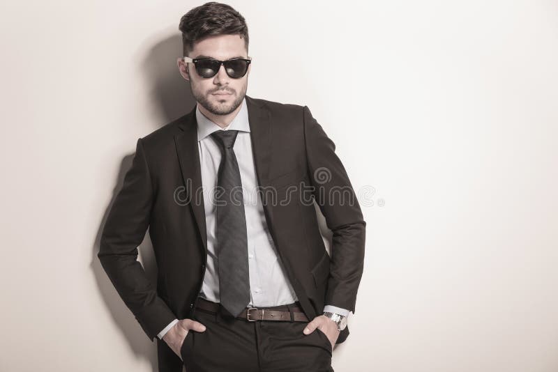 Gafas de sol que llevan atractivas serias y frescas del hombre de negocios