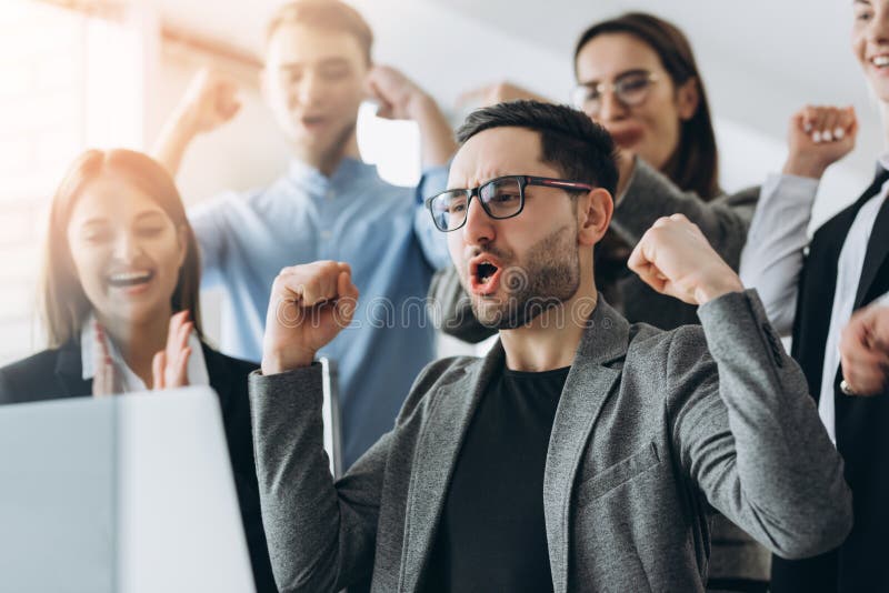 Gagnants quotidiens Groupe de gens d'affaires heureux dans la tenue de d? tente fut? e regardant l'ordinateur portable et faire des photos stock