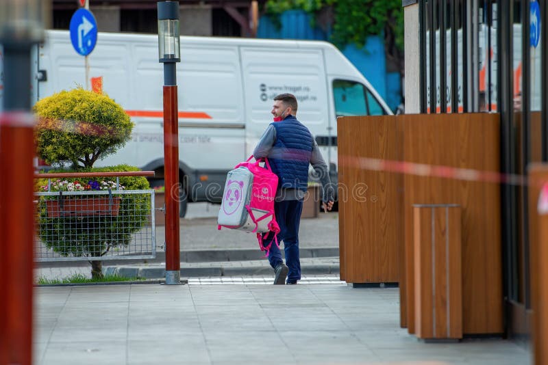 Galati, Romania - May 06, 2020: Food order online via Foodpanda being delivered by foodpanda delivery boy. Foodpanda is up coming online delivery company in Europe.