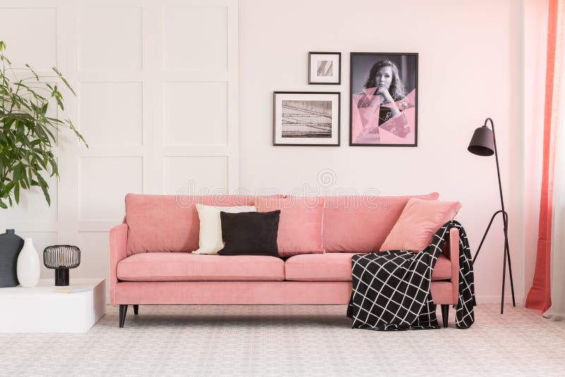 Galeria plakaty na ścianie w modnym żywym izbowym wnętrzu z różową leżanką i przemysłową lampą