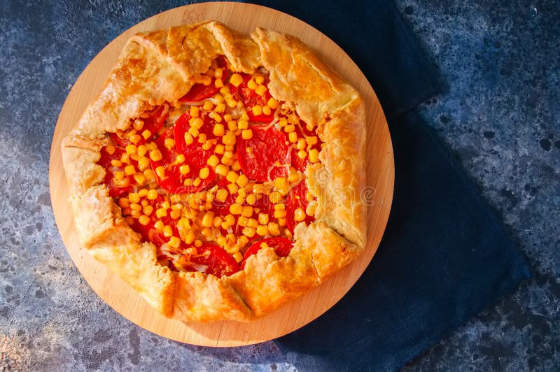 Galette del mais e del pomodoro su un bordo di legno Vista superiore blu immagini stock libere da diritti Galette del mais e del pomodoro su un bordo di legno Vista superiore blu immagini stock libere da diritti