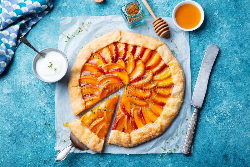 Galette della pesca, torta, dolce con crema su fondo blu Vista superiore immagine stock Galette della pesca, torta, dolce con crema su fondo blu Vista superiore immagine stock