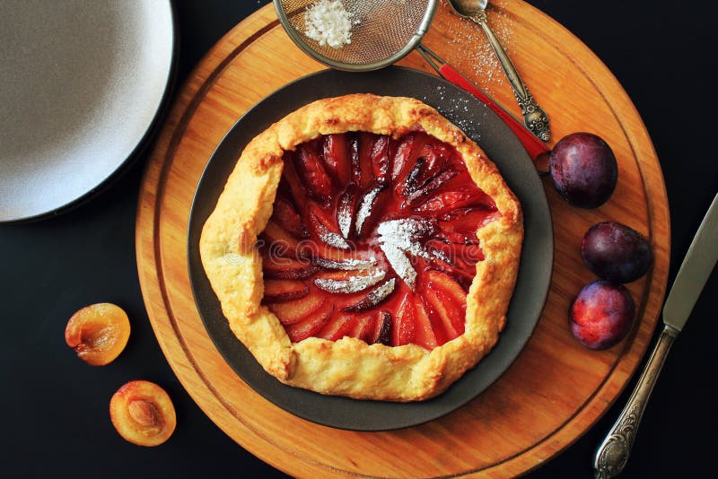 Galette hecho en casa fresco delicioso del ciruelo en la tabla foto de archivo libre de regalías Galette hecho en casa fresco delicioso del ciruelo en la tabla foto de archivo libre de regalías
