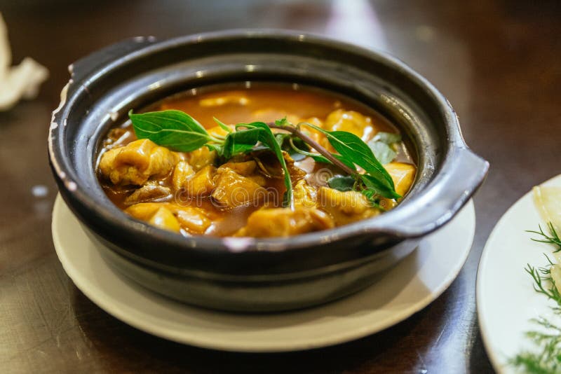 A galinha cozinhada estilo de Hanoi na cobertura do potenciômetro de argila com manjericão sae no restaurante em Hanoi vietnam imagem de stock A galinha cozinhada estilo de Hanoi na cobertura do potenciômetro de argila com manjericão sae no restaurante em Hanoi vietnam imagem de stock