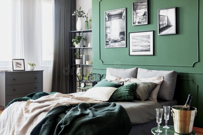Galleri av den svartvita affischen p? den gr?na v?ggen bak konungformats?ng med kuddar och filten arkivbild Galleri av den svartvita affischen p? den gr?na v?ggen bak konungformats?ng med kuddar och filten arkivbild