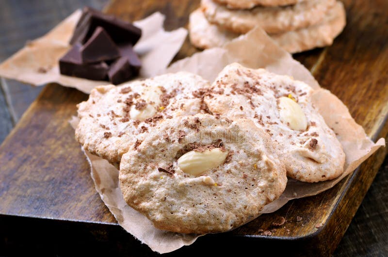 Galletas de almendra en el papel de la hornada fotografía de archivo Galletas de almendra en el papel de la hornada fotografía de archivo