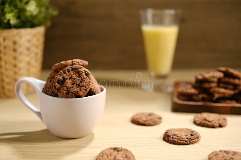 Galletas de chocolate caseras sobre una mesa de madera servidas con una botella de leche. concepto de panadería con espacio de copia para texto