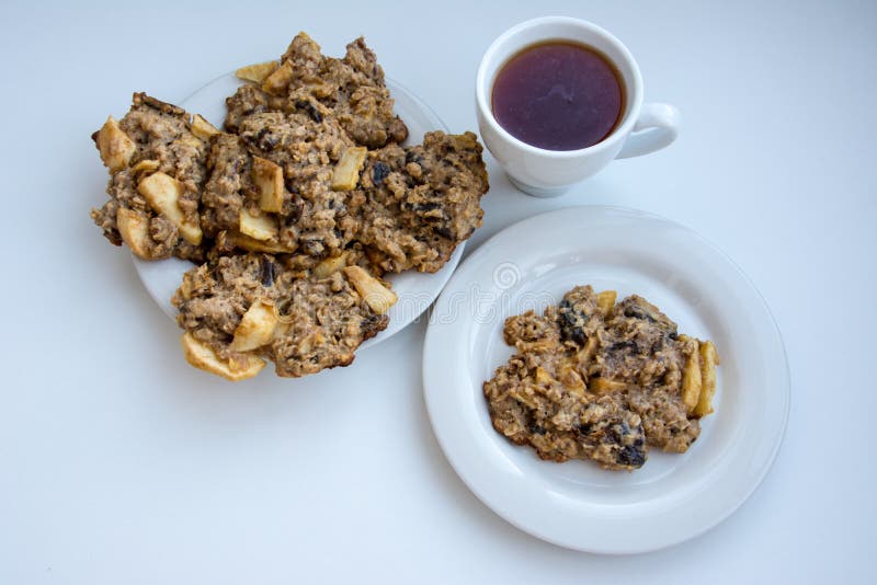 Galletas de harina de avena hechas en casa en la placa con el casquillo del té imagen de archivo Galletas de harina de avena hechas en casa en la placa con el casquillo del té imagen de archivo