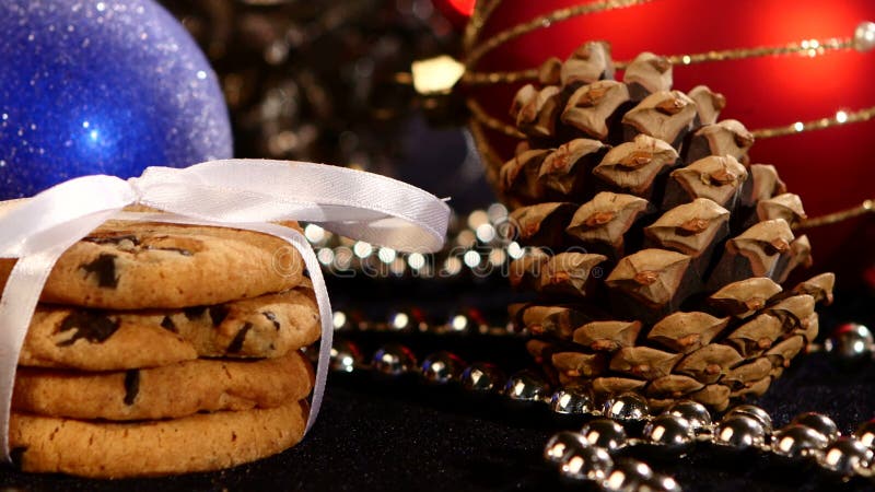 Galletas de la Navidad con la decoración, cono del pino encendido