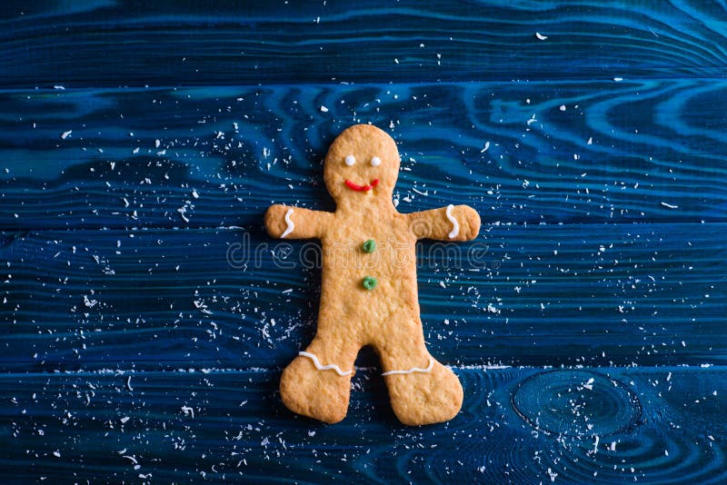 Galletas hechas en casa de la Navidad del primer en la forma de hombre de pan de jengibre en la tabla de la marina de guerra foto de archivo Galletas hechas en casa de la Navidad del primer en la forma de hombre de pan de jengibre en la tabla de la marina de guerra foto de archivo