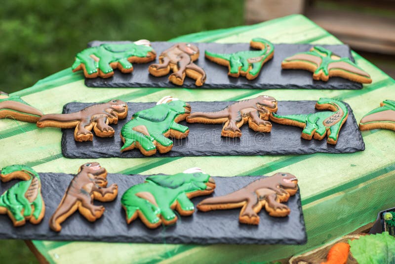 Galletas hechas en casa del pan de jengibre con la decoraci?n de congelaci?n hecha a mano como dinosaurios divertidos Superficie imagen de archivo libre de regalías Galletas hechas en casa del pan de jengibre con la decoraci?n de congelaci?n hecha a mano como dinosaurios divertidos Superficie imagen de archivo libre de regalías