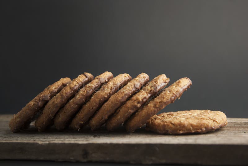 Galletas o galletas de harina de avena con la avena, las nueces, los huevos y la harina en woodenboard oscuro marrón con el fondo imagen de archivo Galletas o galletas de harina de avena con la avena, las nueces, los huevos y la harina en woodenboard oscuro marrón con el fondo imagen de archivo